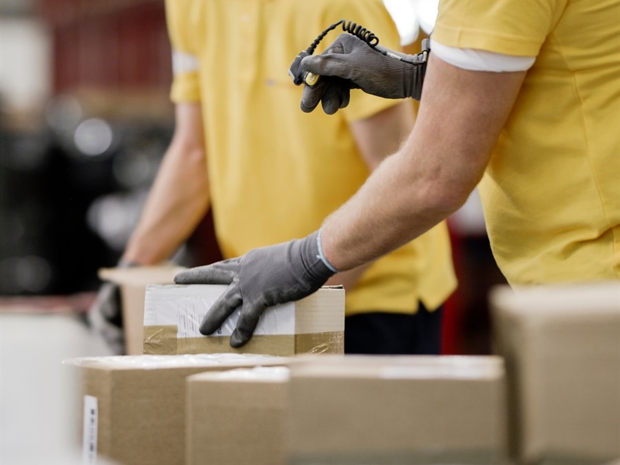 Box It warehouse staff in branded uniforms scanning and packing e-commerce orders